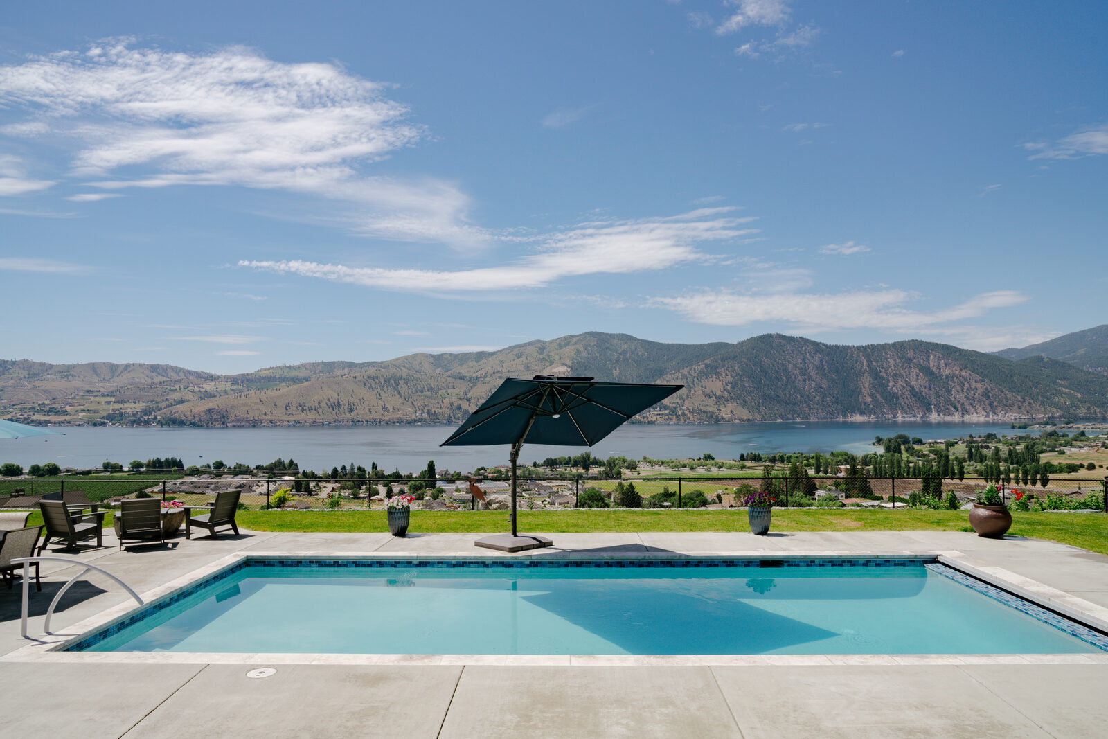 Custom pool with lake panorama and patio umbrella