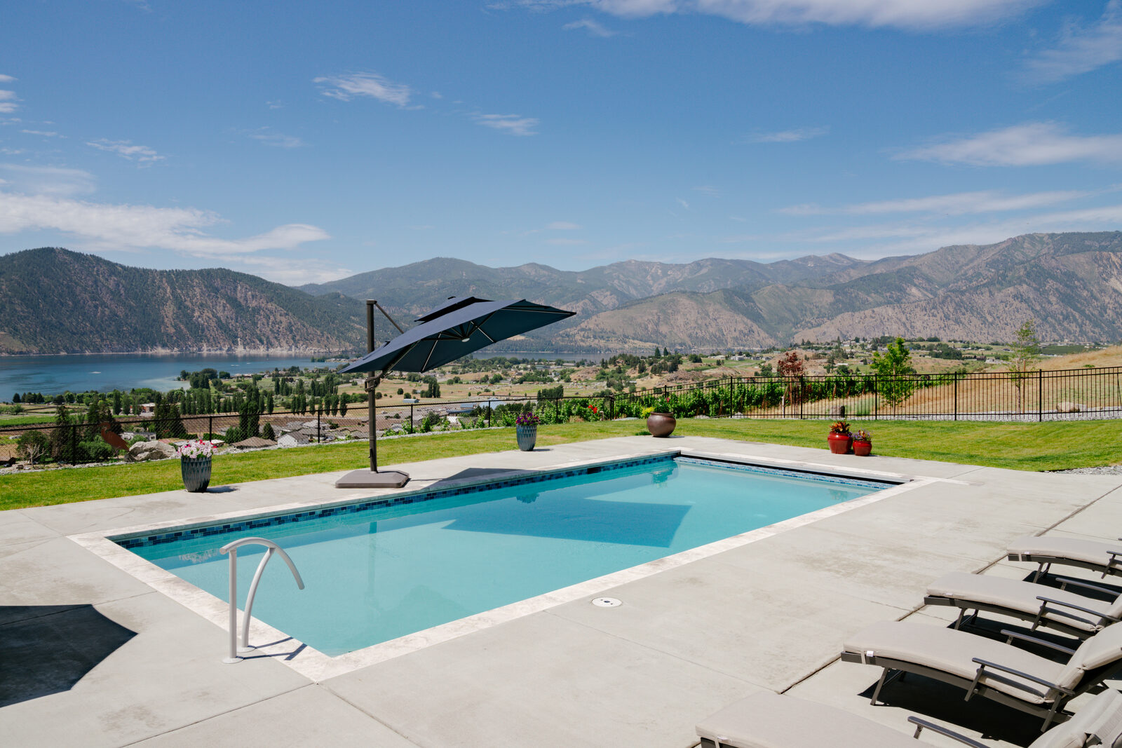 Custom pool with cantilever umbrella and sweeping mountain valley view