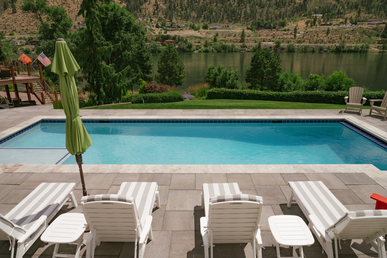 Riverside custom pool with crisp concrete deck and mountain backdrop