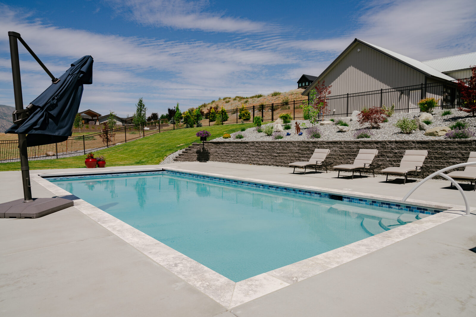 Custom pool with stacked stone retaining wall