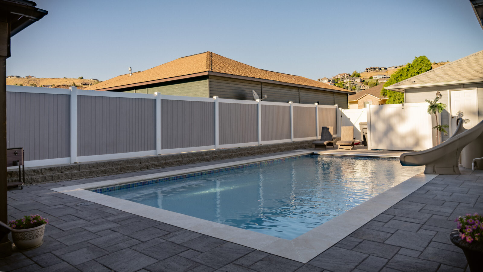 Custom pool with vinyl privacy fencing and hilltop view