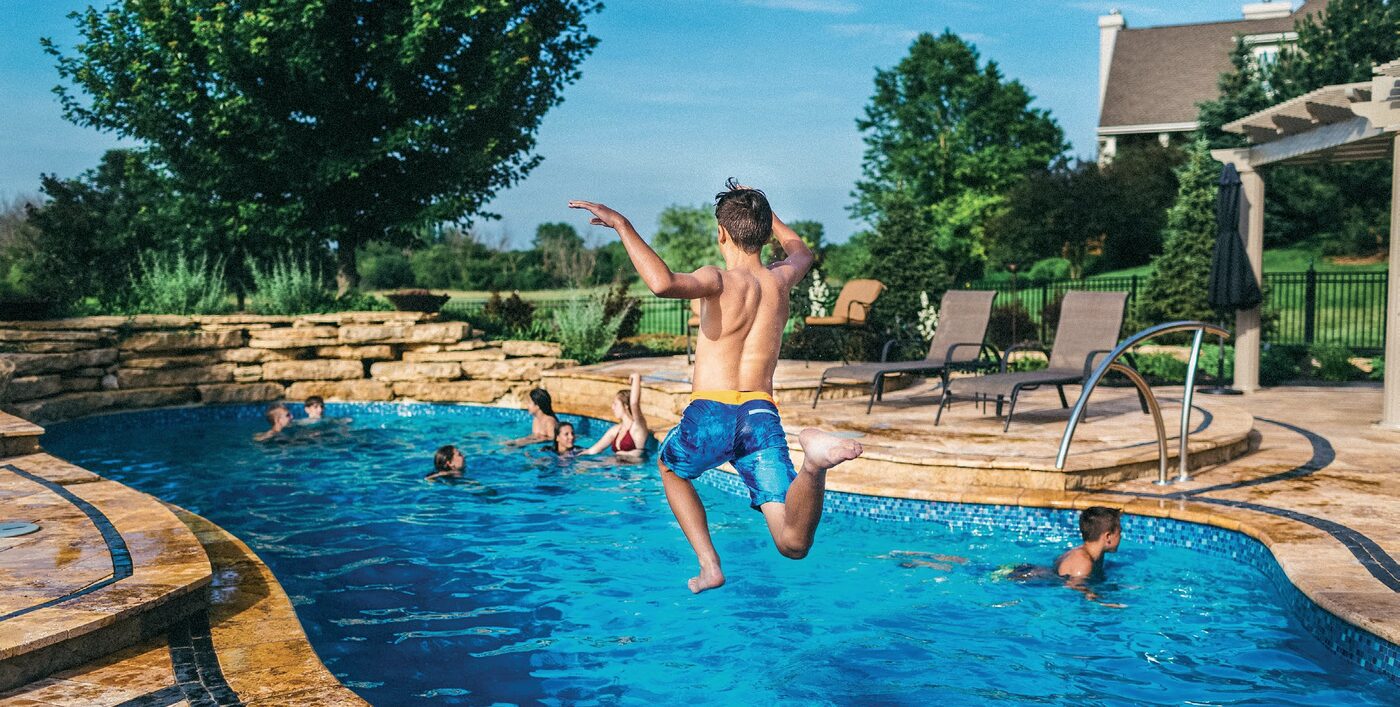 A family enjoying a fiberglass pool on a summer day